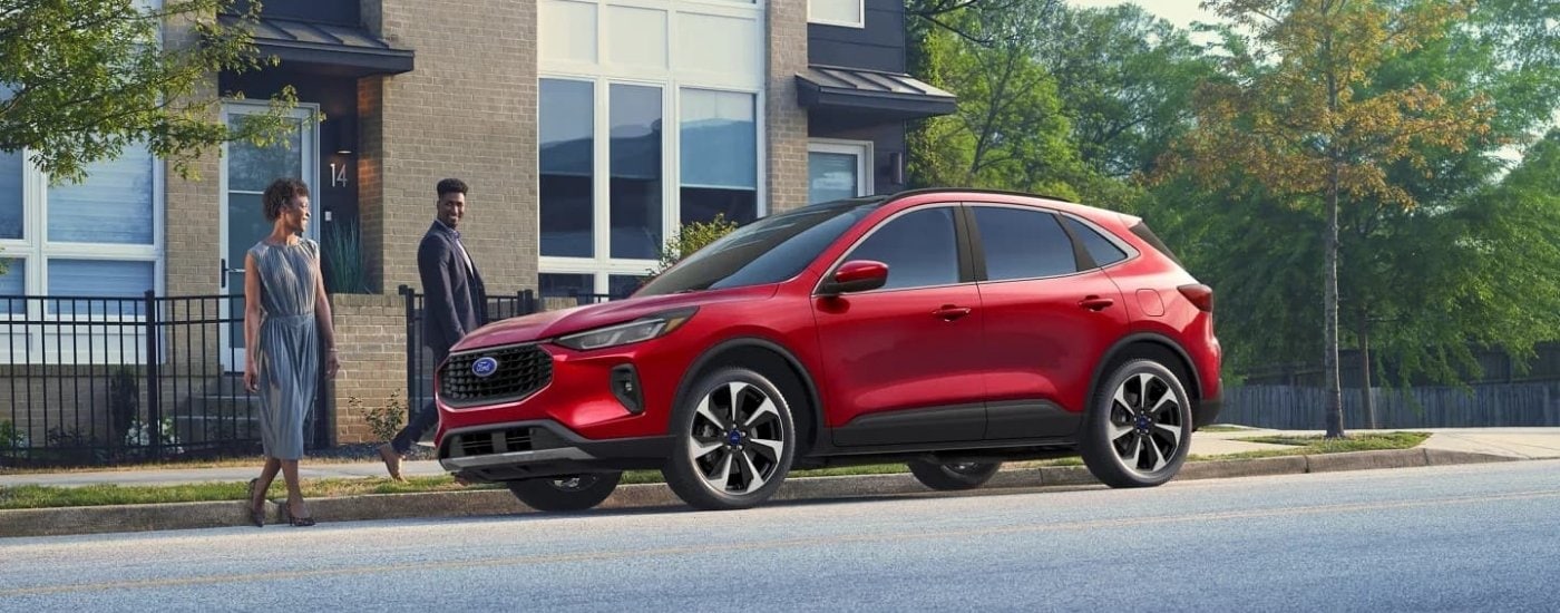 A red  2024 Ford Escape is shown parked near a modern building.