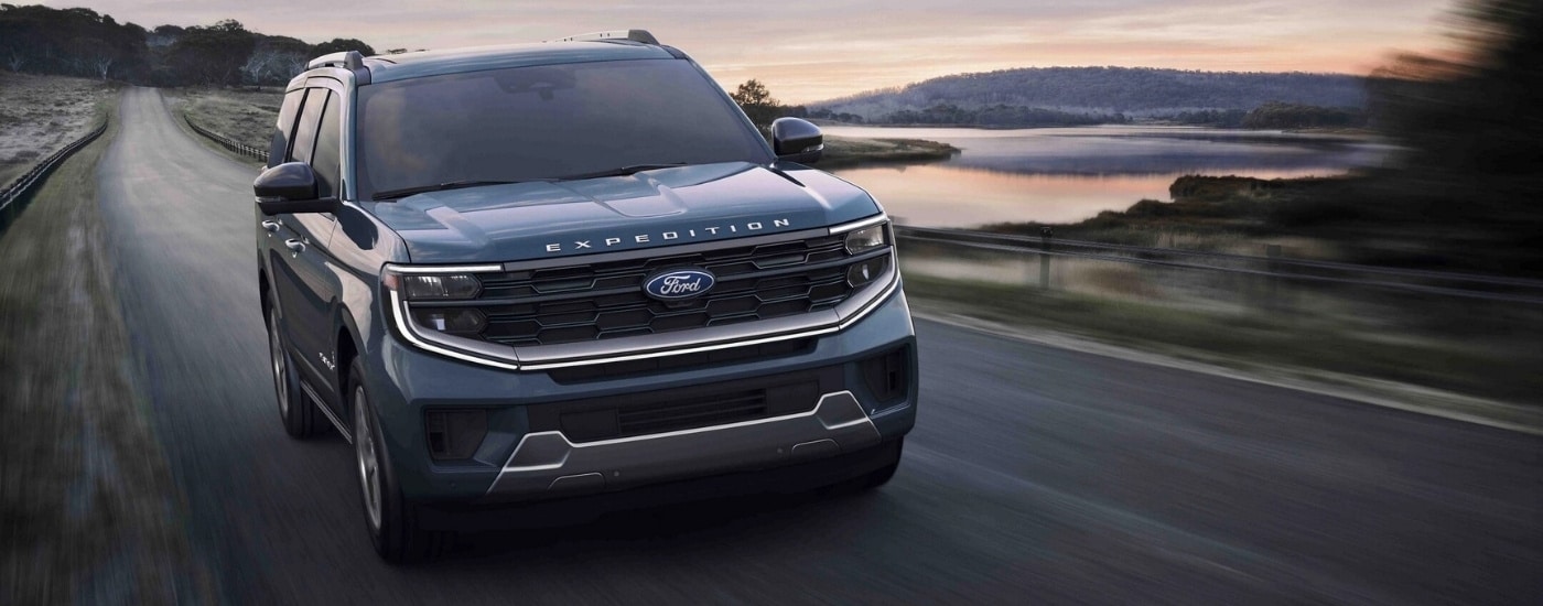 A blue 2025 Ford Expedition Platinum driving down a highway