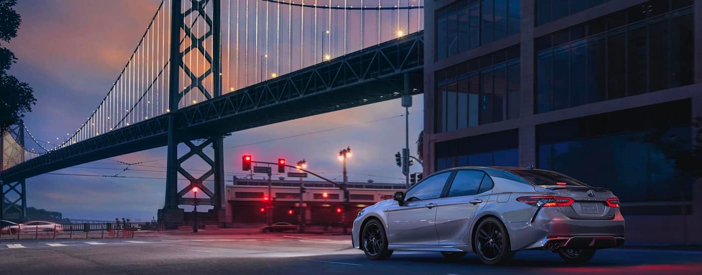 Grey 2020 Toyota Camry driving underneath a bridge from a used car dealer near Upper Sandusky.