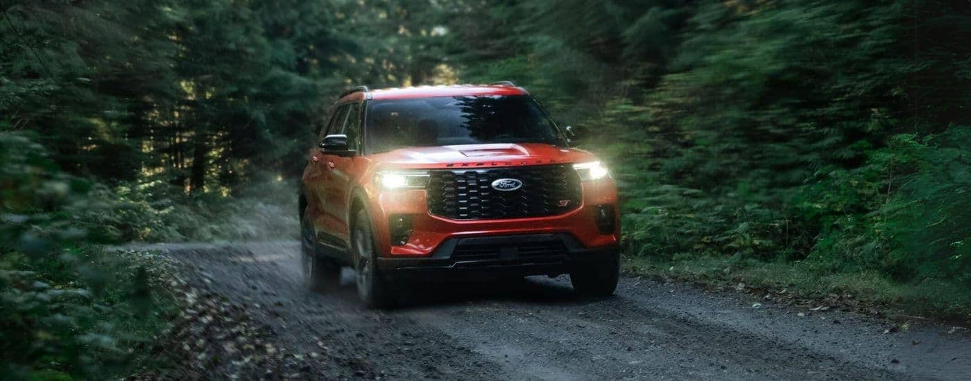 A red 2025 Ford Explorer ST driving off-road on a trail