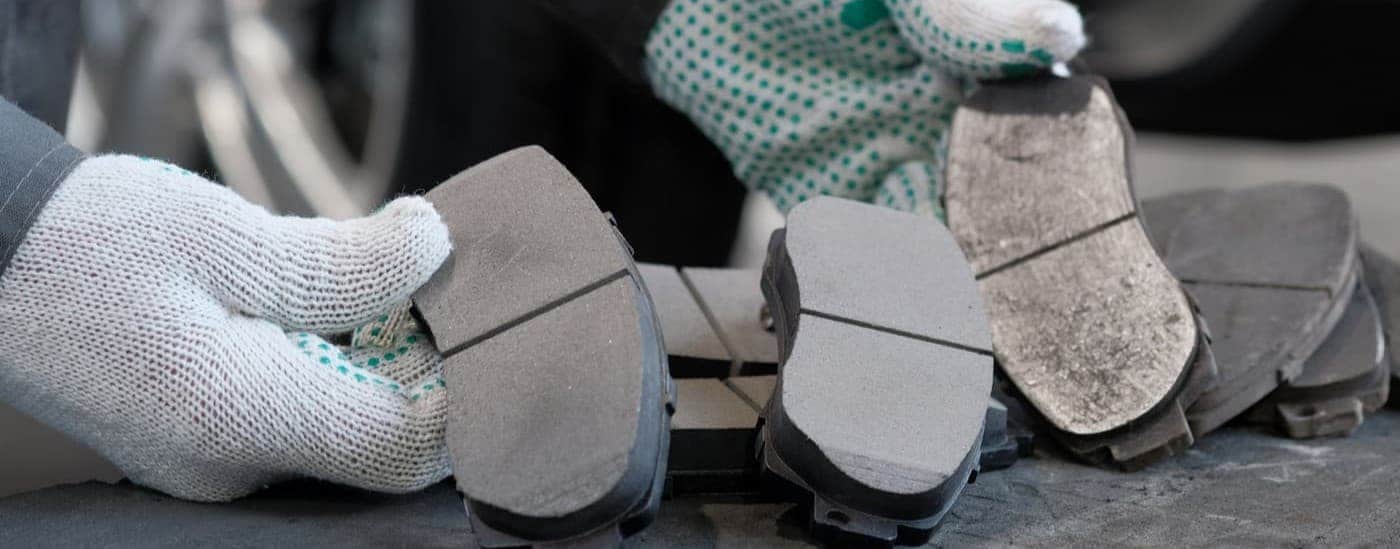 A technician holding brake pads.