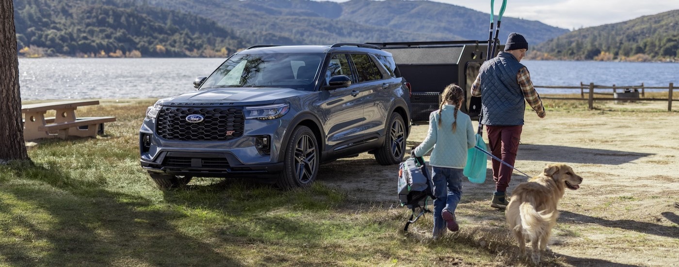 A blue 2025 Ford Explorer ST parked near a lake.