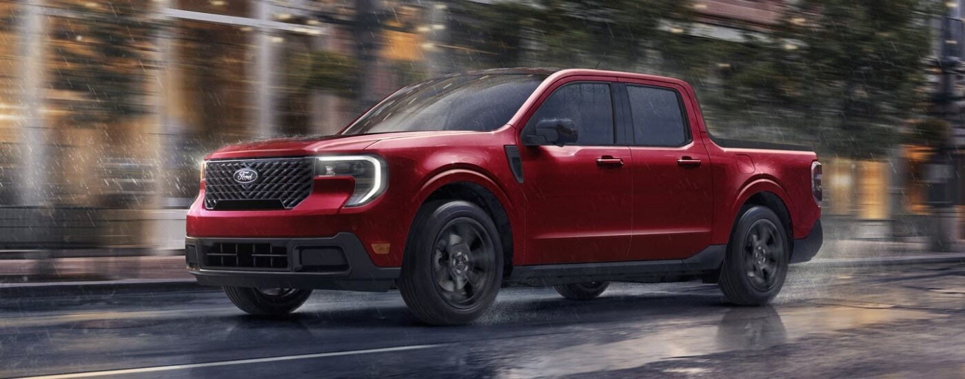 A red 2025 Ford Maverick for sale is shown driving on wet pavement.