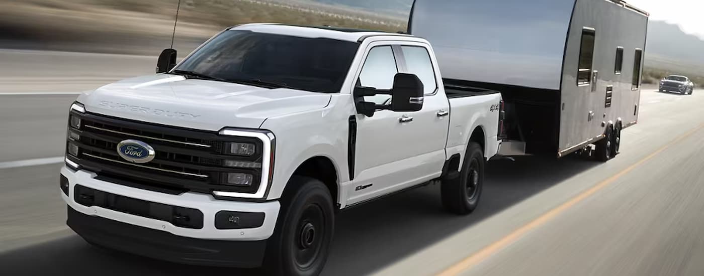 White 2025 Ford F-350 Platinum towing a trailer.