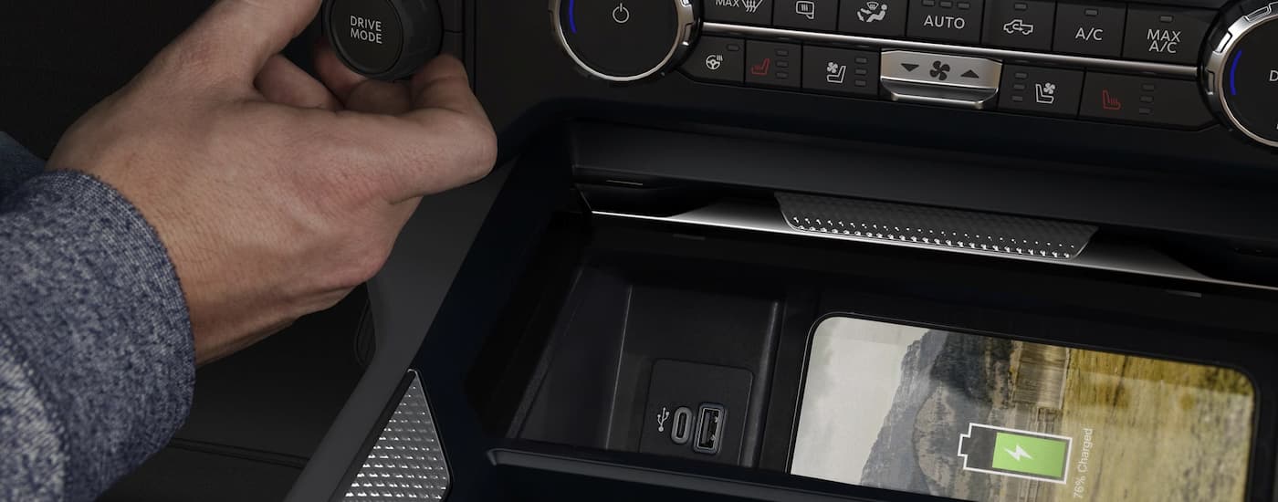 Man charging his phone in the center console of 2025 Ford F-250 Super Duty for sale near Defiance.