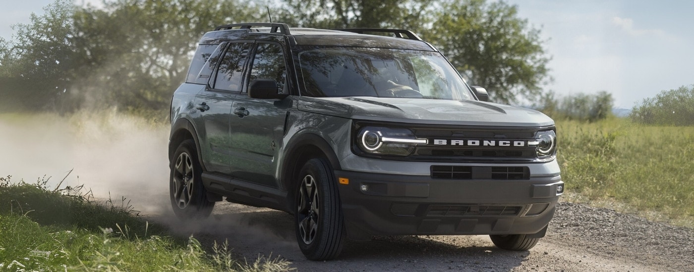 A grey 2024 Ford Bronco Sport Outer Banks is shown driving on a trail.