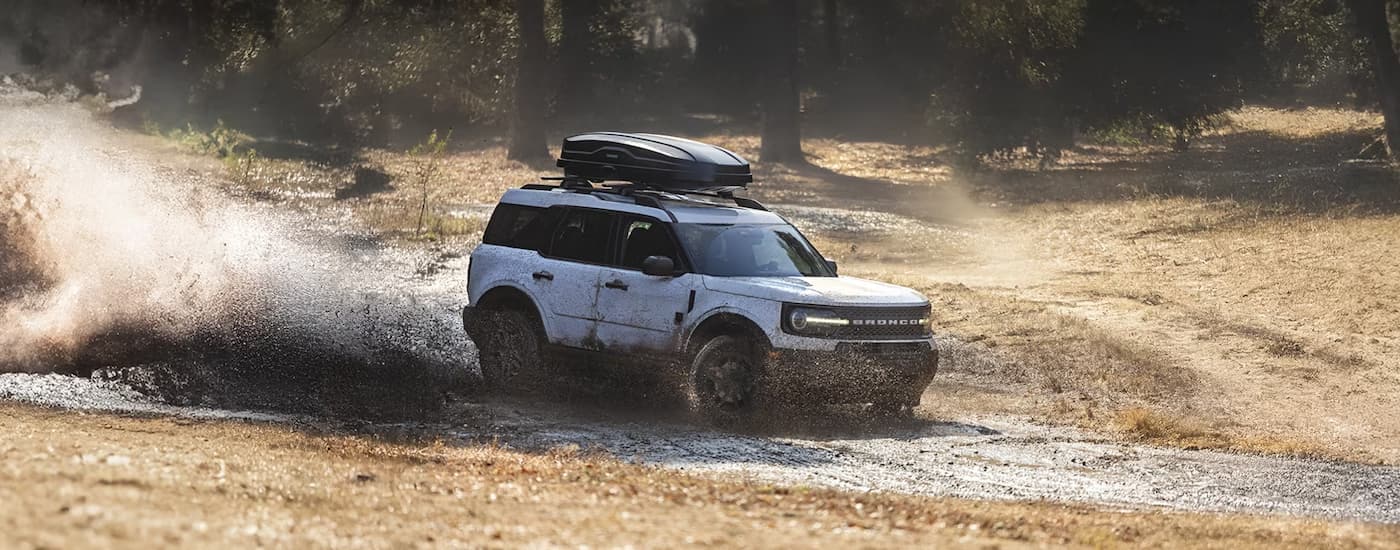 White 2025 Ford Bronco Sport off-roading on a muddy trail