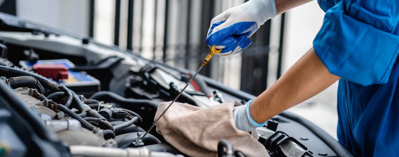 A mechanic holding a dipstick.