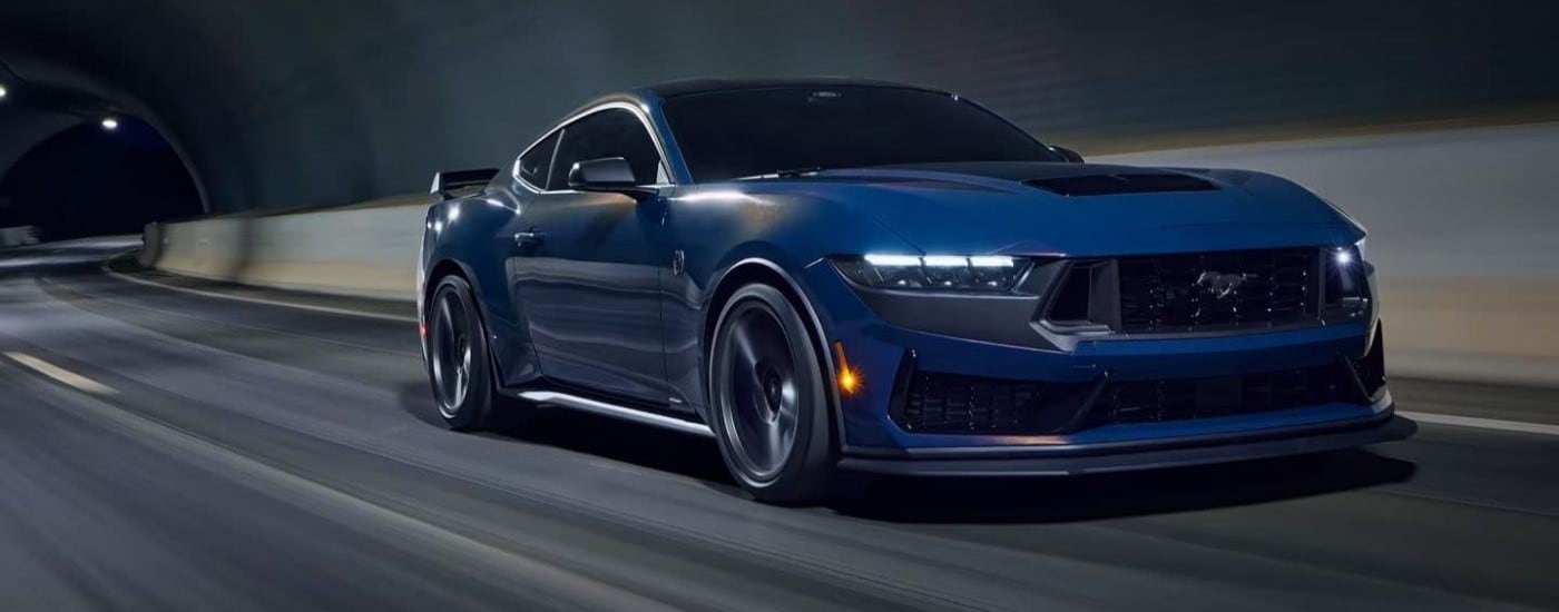 Blue 2024 Ford Mustang Dark Horse driving to a car dealership near Defiance