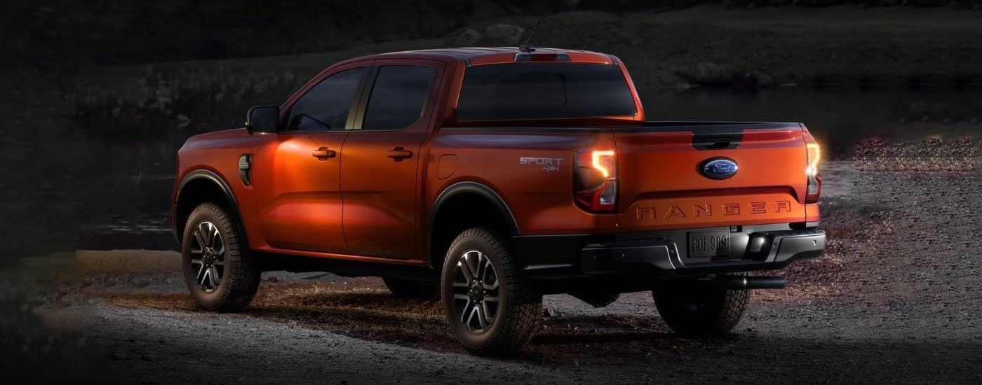 A red 2024 Ford Ranger Sport parked at night with its lights on
