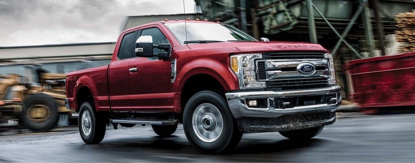 A red 2018 Ford F-350 Super Duty is shown driving at a construction site.