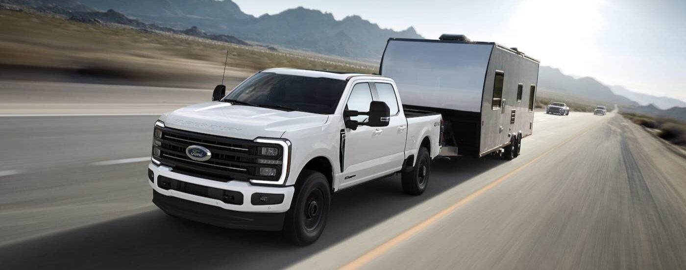 A white 2025 Ford F-350 for sale near Bowling Green is shown towing a trailer.