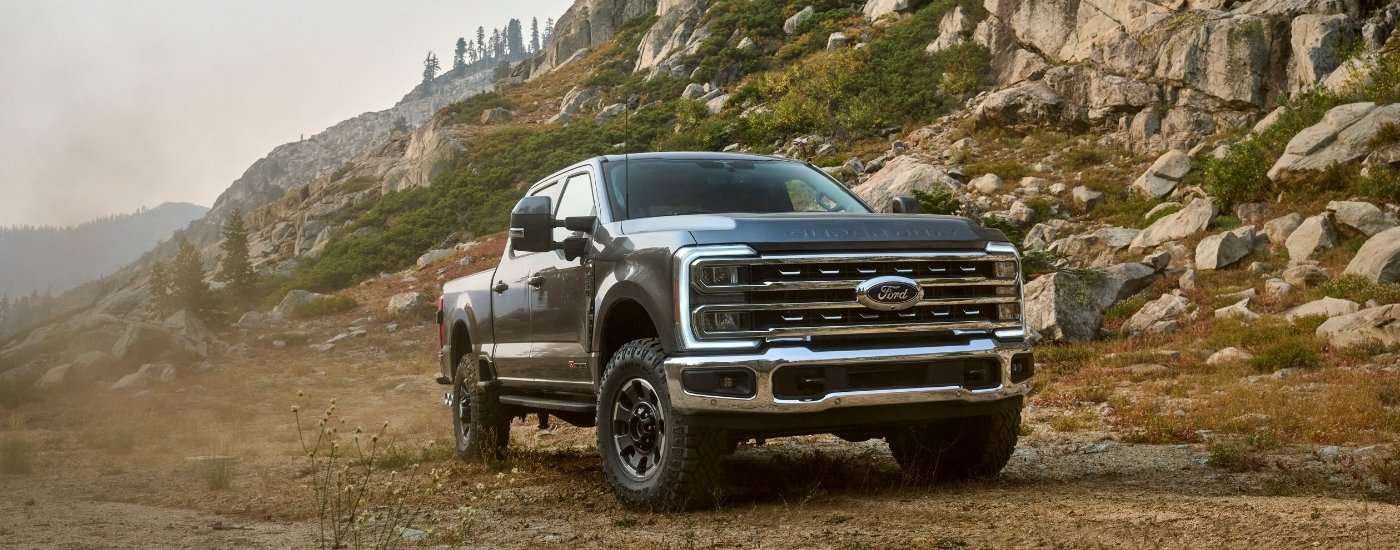 A dark grey 2024 Ford F-250 Tremor parked off-road near rocks.