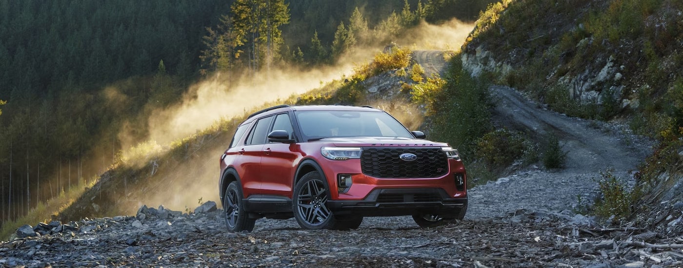 A red 2025 Ford Explorer ST parked off-road in a clearing.