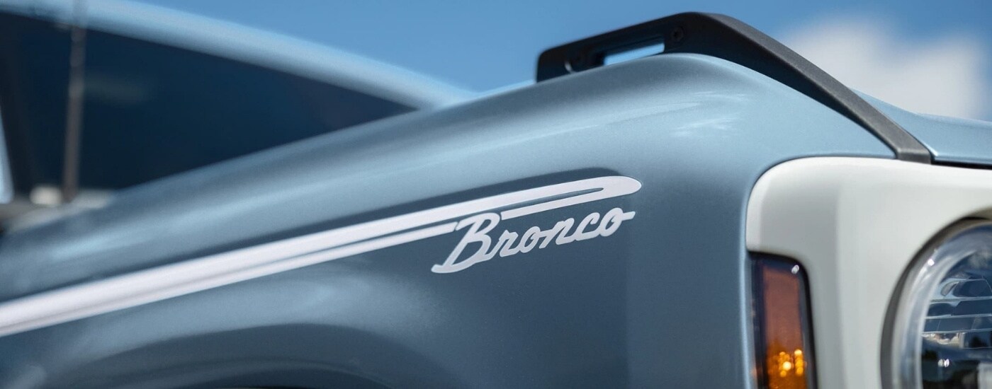 A retro Bronco badge is shown on light blue 2023 Ford Bronco for sale near Carey.