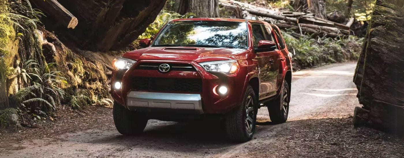 Red 2023 Toyota 4Runner Off-Road driving down a dirt road.
