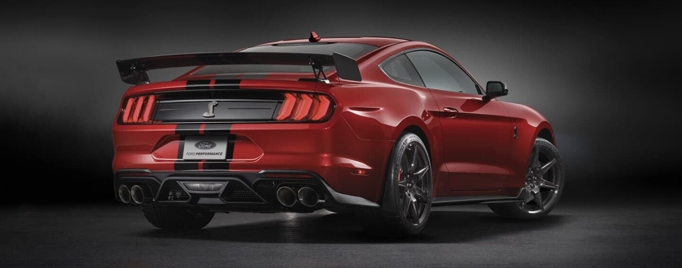 A red 2022 Ford Mustang GT500 is shown from the rear against a black background.