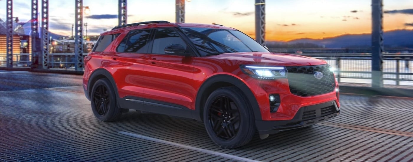 Red 2025 Ford Explorer ST driving on a city bridge