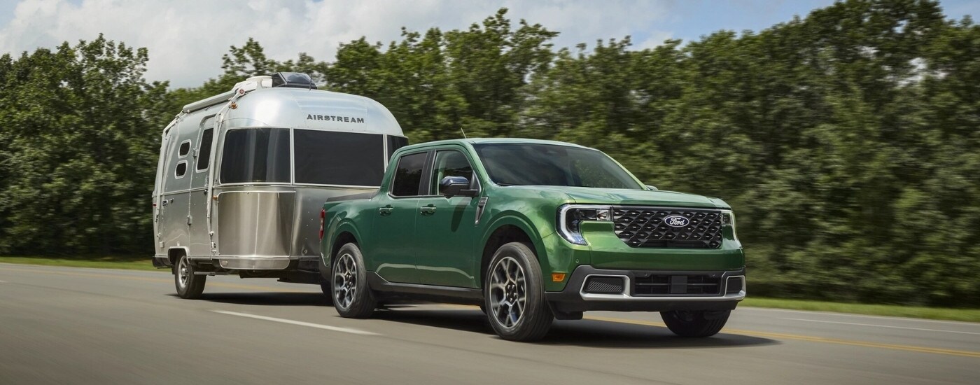 A green 2025 Ford Maverick Lariat towing an Airstream camper