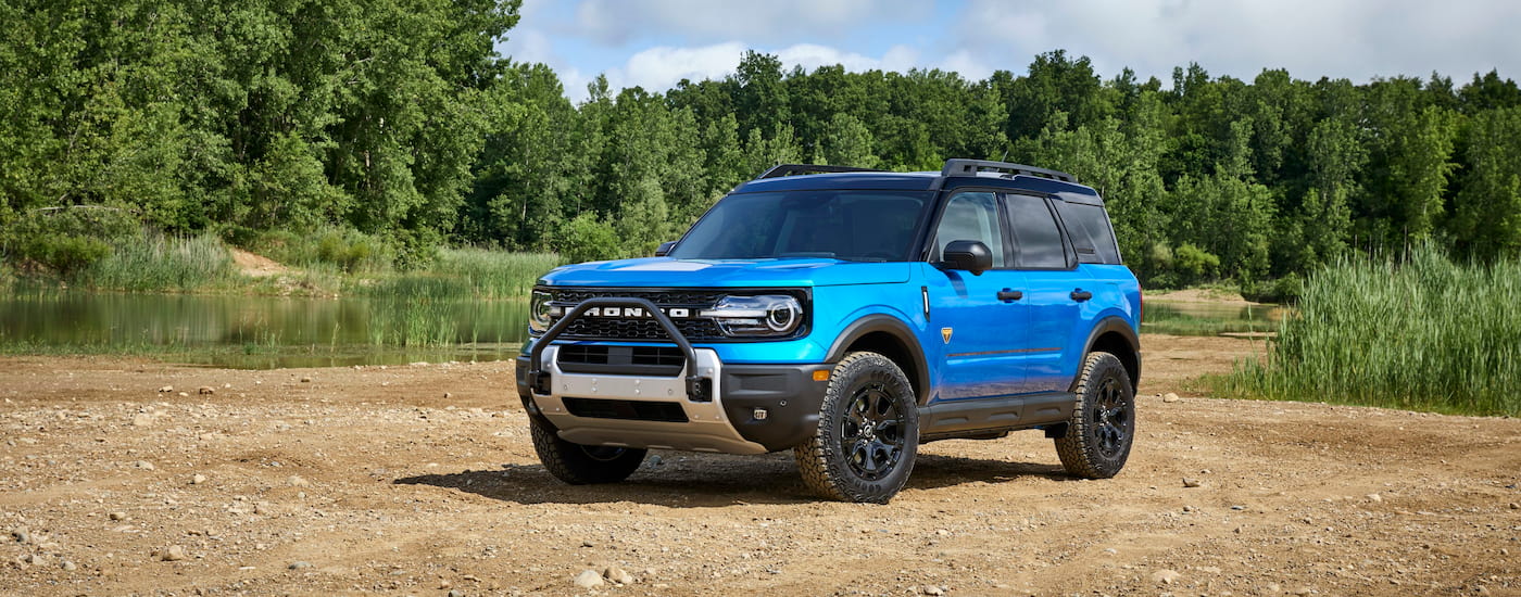 A blue 2025 Ford Bronco Sport Badlands Sasquatch parked near a small pond.