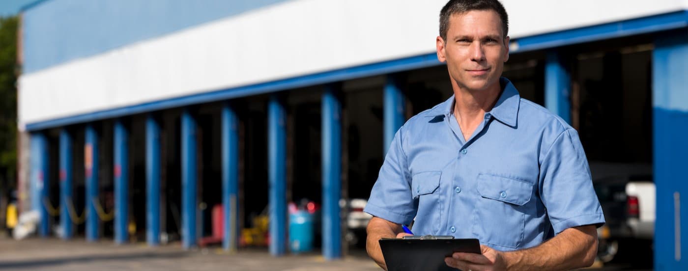 A mechanic holding a clipboard.