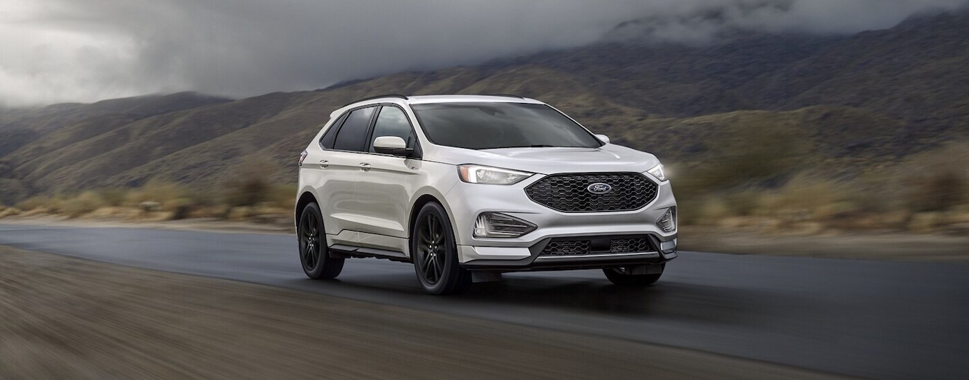 A white 2024 Ford Edge driving to a Ford dealer near North Baltimore.