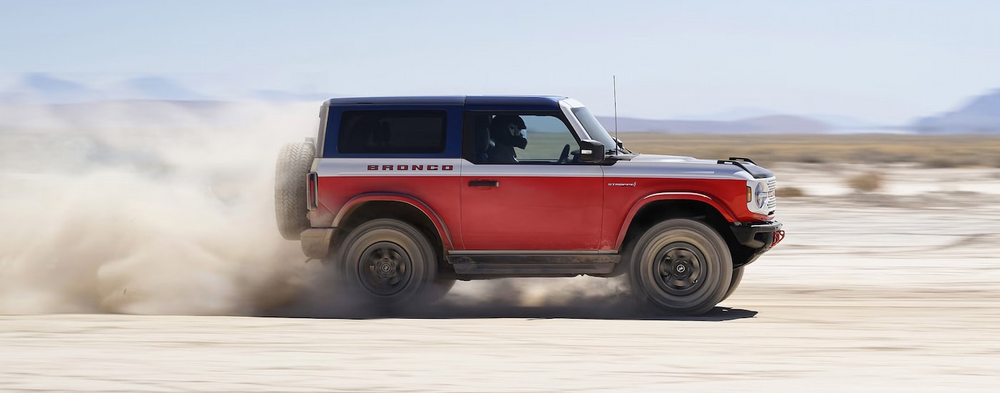Side view of a red 2025 Ford Bronco Sport Stroppe Edition racing through sand.
