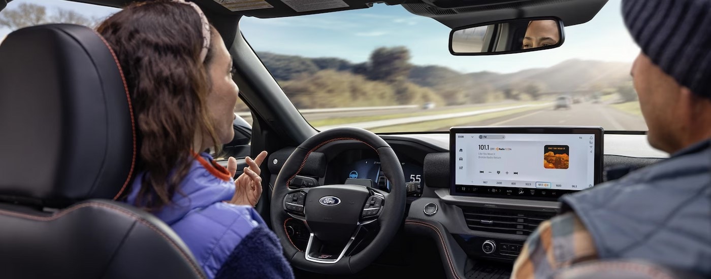 Two people driving in a 2025 Ford Explorer for sale near Nevada.
