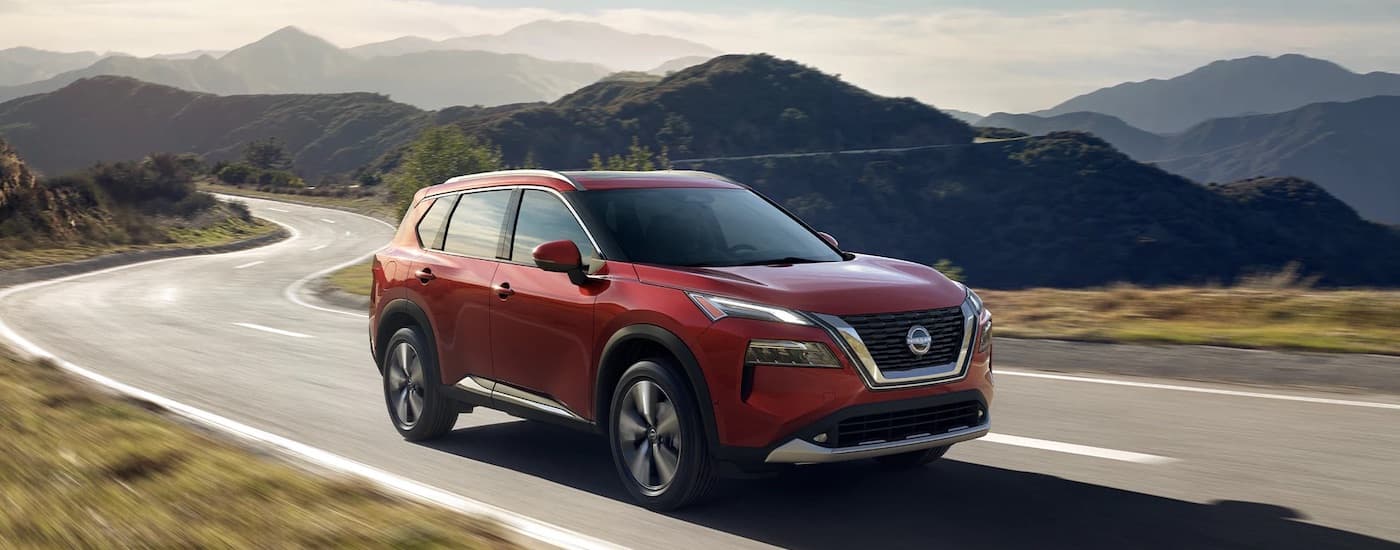 A red 2023 Nissan Rogue from the front at an angle.