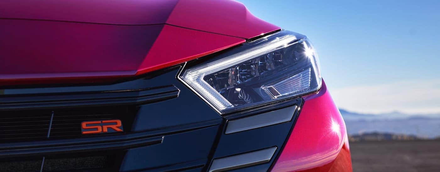 Grille and headlight on a red 2025 Nissan Versa SR