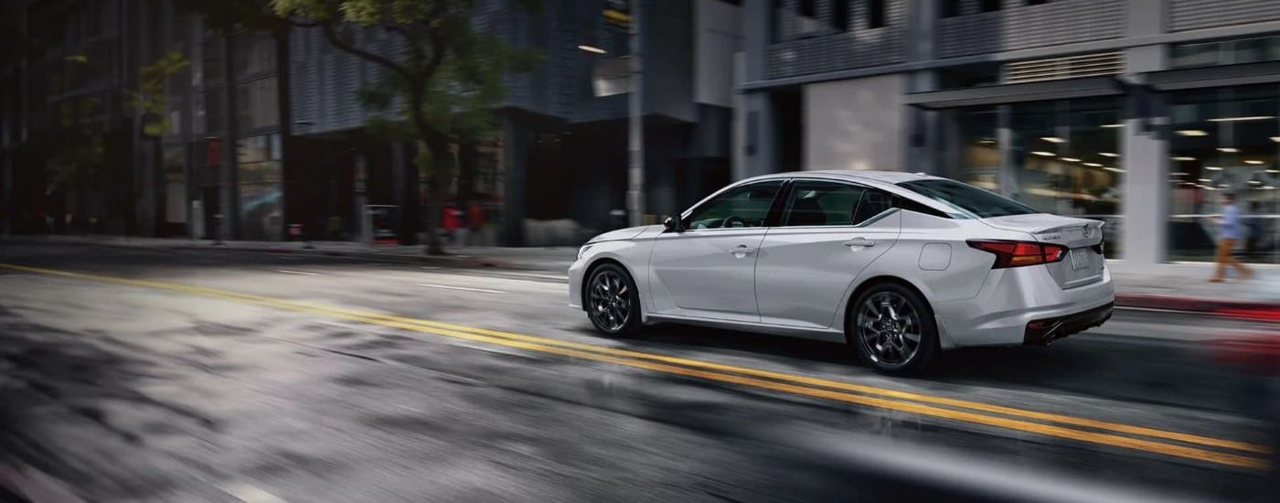 White 2025 Nissan Altima driving through a city