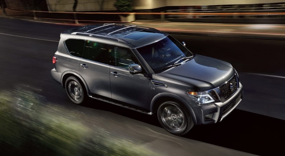 A grey 2018 Nissan Armada is shown driving on a city street.