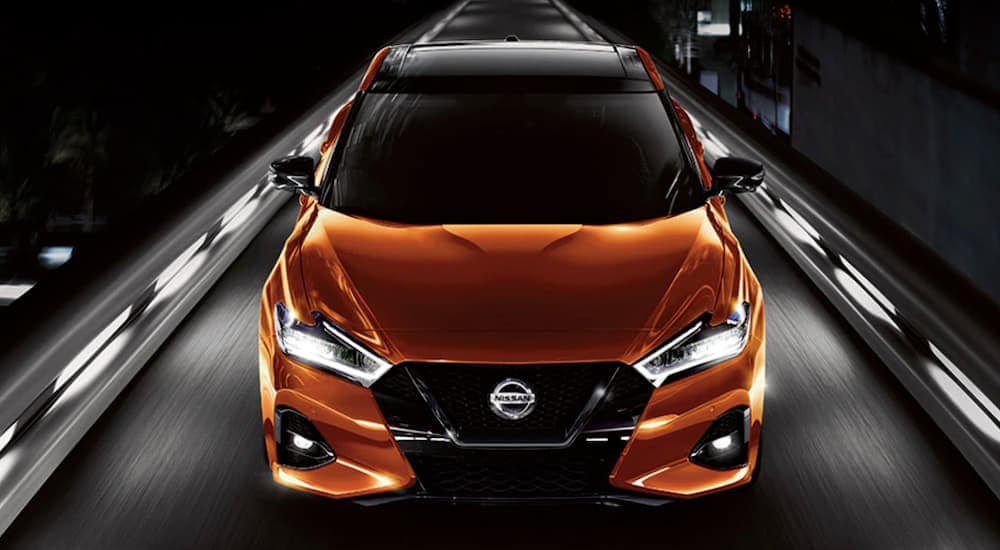 Front view of an orange 2021 Nissan Maxima driving.