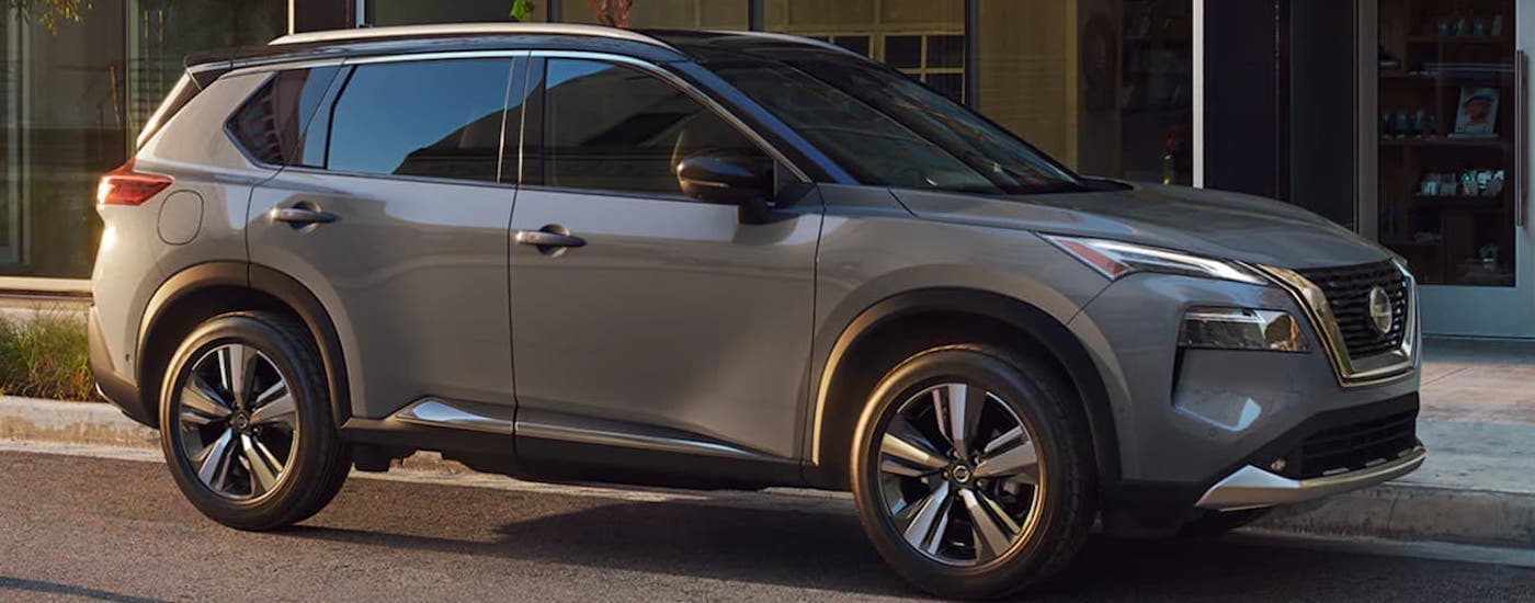 A grey 2021 Nissan Rogue parked beside a building after visiting a dealer with a used Nissan for sale near Troy.