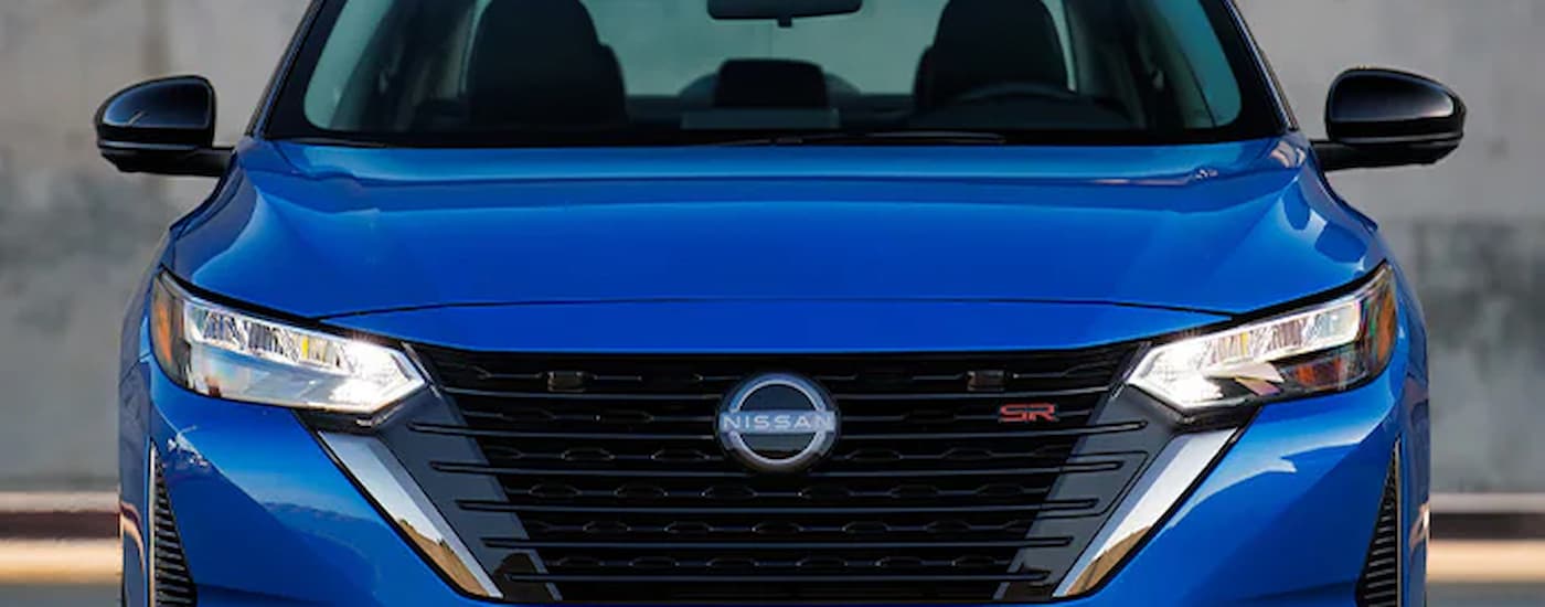 A close up of the front grille on a blue 2024 Nissan Sentra for sale.