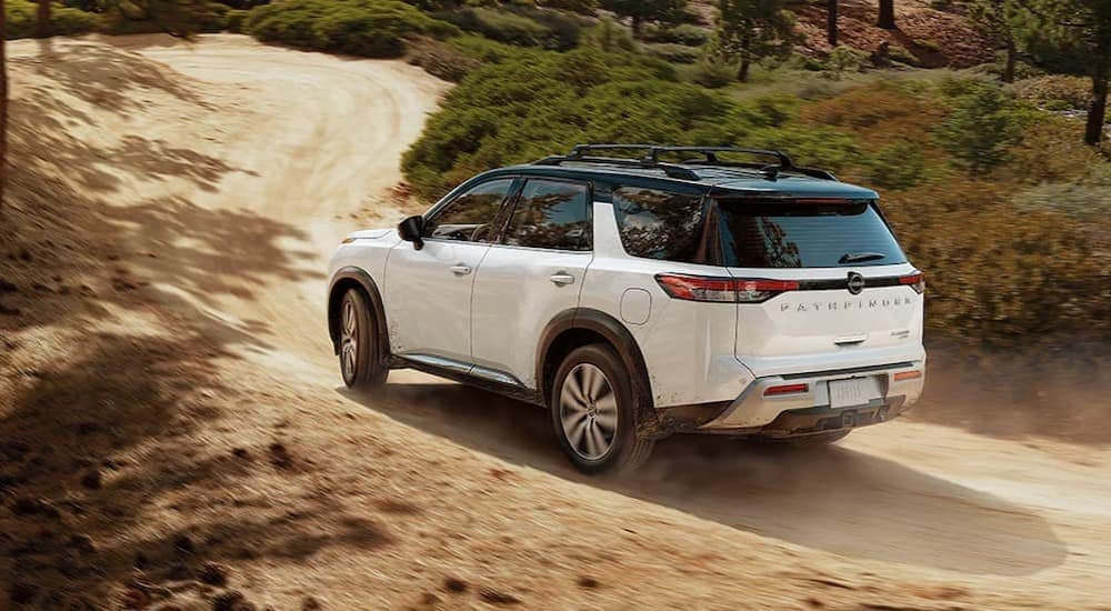 A white 2025 Nissan Pathfinder off-roading.