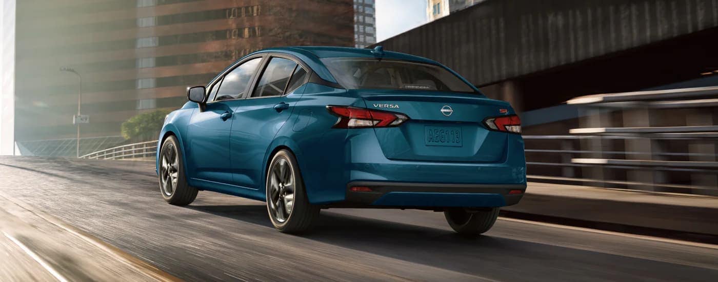 Blue 2025 Nissan Versa driving on a highway ramp