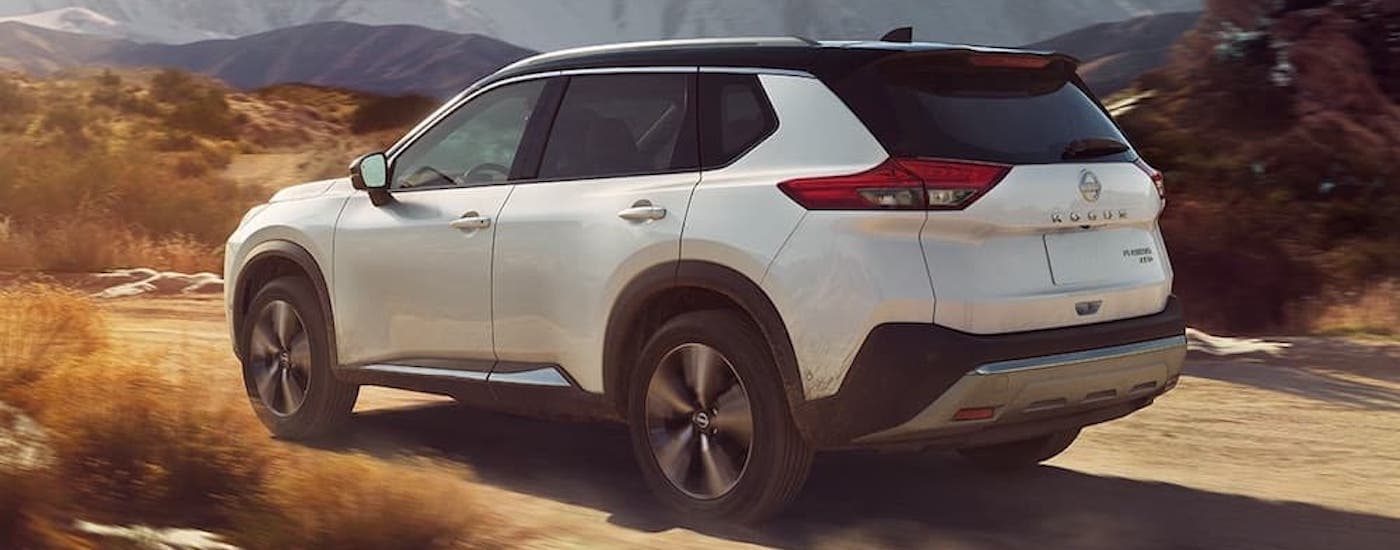 A white 2023 Nissan Rogue from the side.