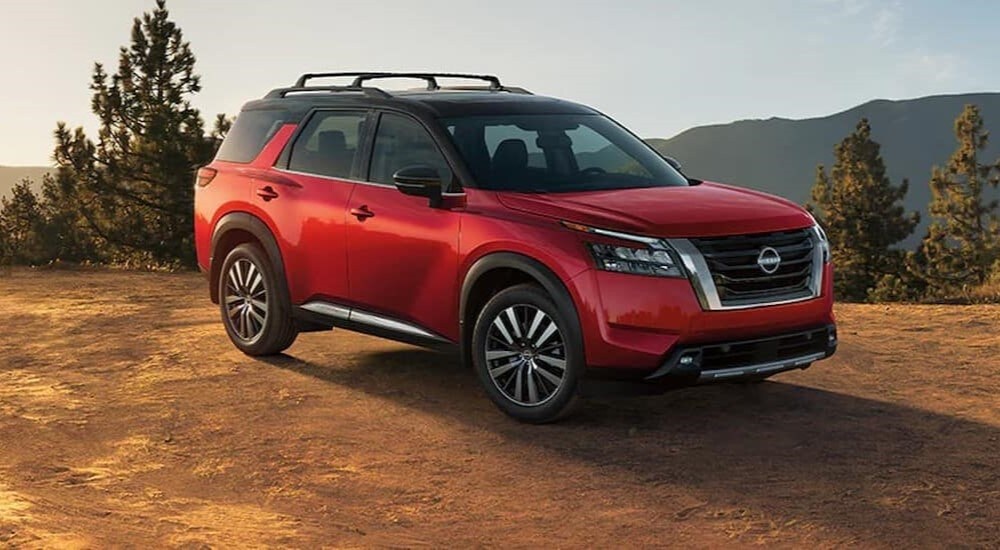 A red 2025 Nissan Pathfinder for sale parked off-road.