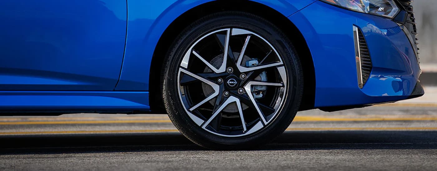 A close up of the side and tire on a blue 2024 Nissan Sentra.