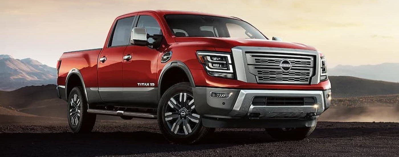 A red 2024 Nissan Titan XD is shown parked off-road.