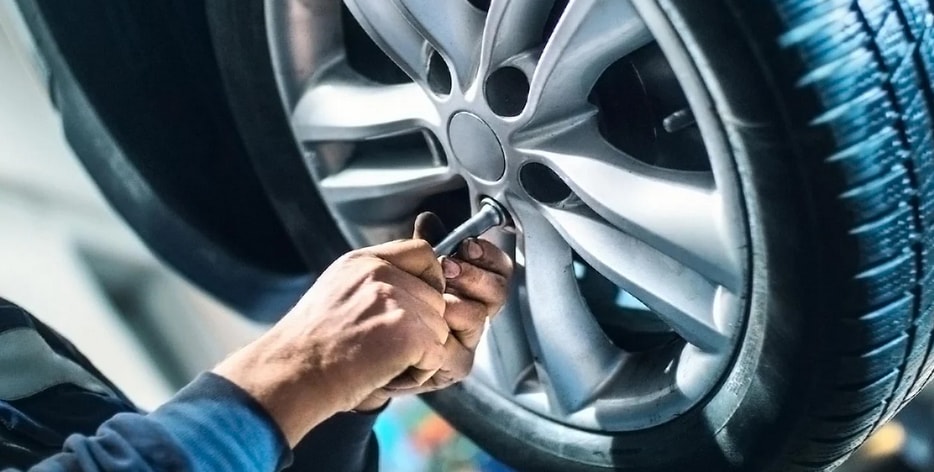 Rensselaer Honda service technician working on a vehicle wheel during Honda maintenance in Troy New York near Latham