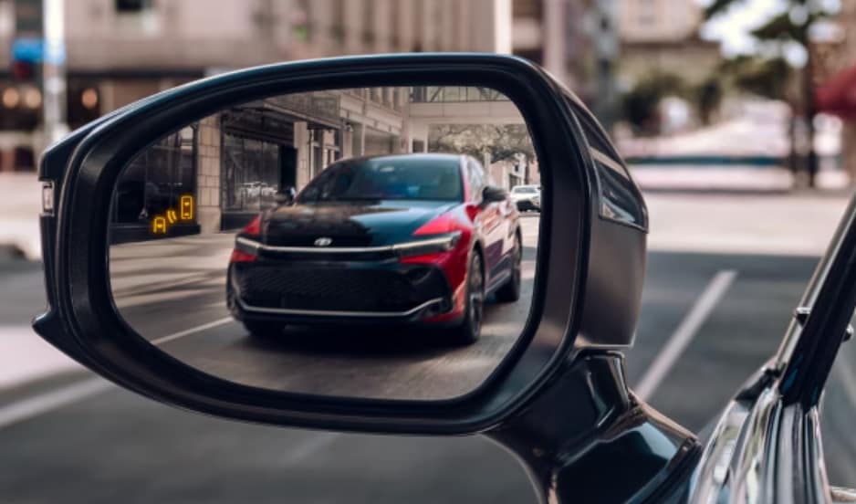 A Toyota Crown in the rear view mirror of another Toyota Crown