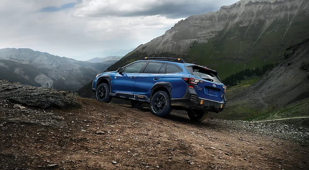 A blue 2022 Subaru Outback Wilderness is shown off-roading after leaving a Subaru dealer.