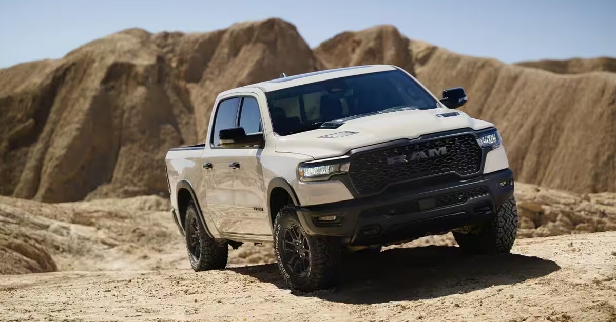 A white 2025 RAM 1500 parked on a rugged desert terrain