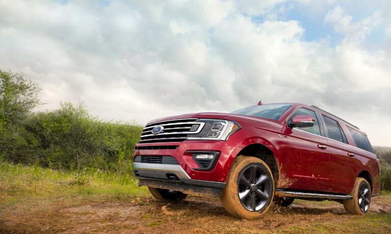 2020 Ford Expedition in red driving off road on a muddy dirt road