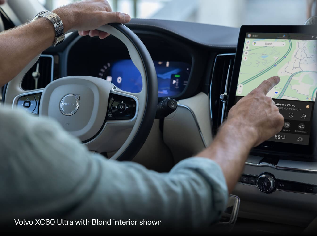 2027 Volvo XC60 Ultra with Blond interior, driver using center touchscreen navigation beside the steering wheel.