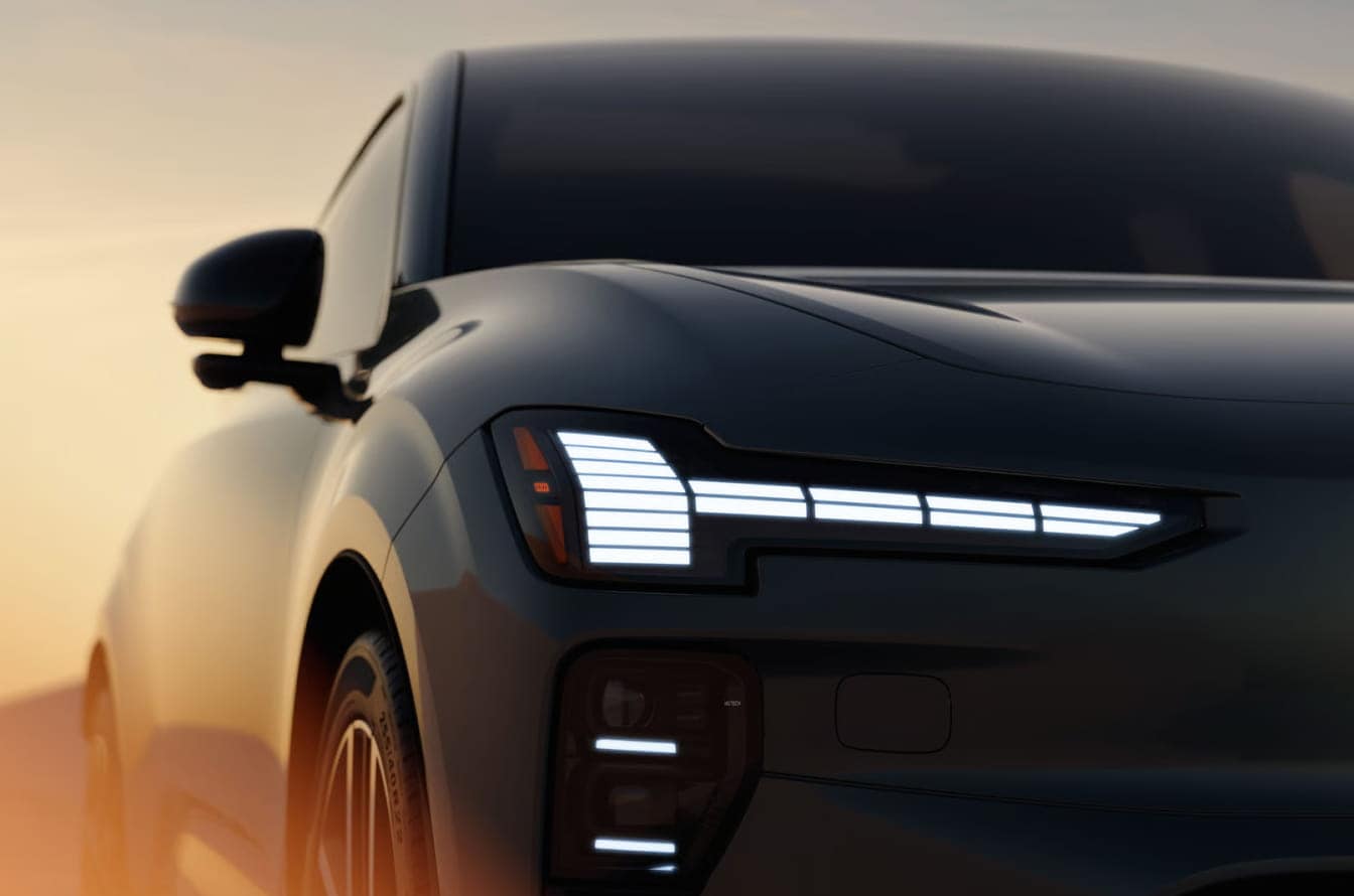 Close-up of a 2026 Volvo EX60, front view at sunset.