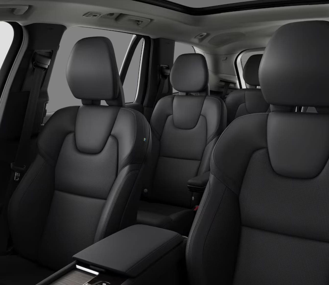 Sleek Volvo XC90 interior featuring black leather seats with a modern design, spacious layout, and panoramic sunroof.