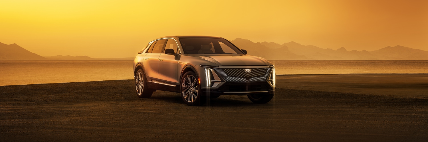 CADILLAC LYRIQ SUV parked outside in a mountain landscape at sunset new CADILLAC LYRIQ
